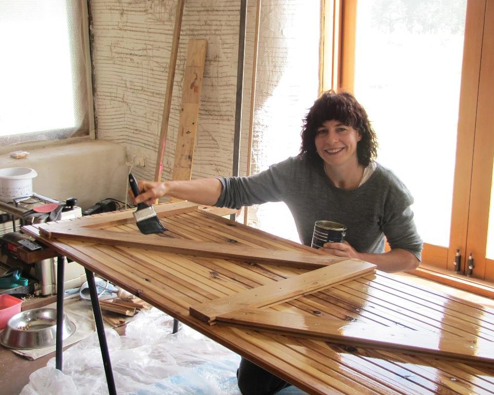 Designer finishing a handmade wooden door in a bright workshop