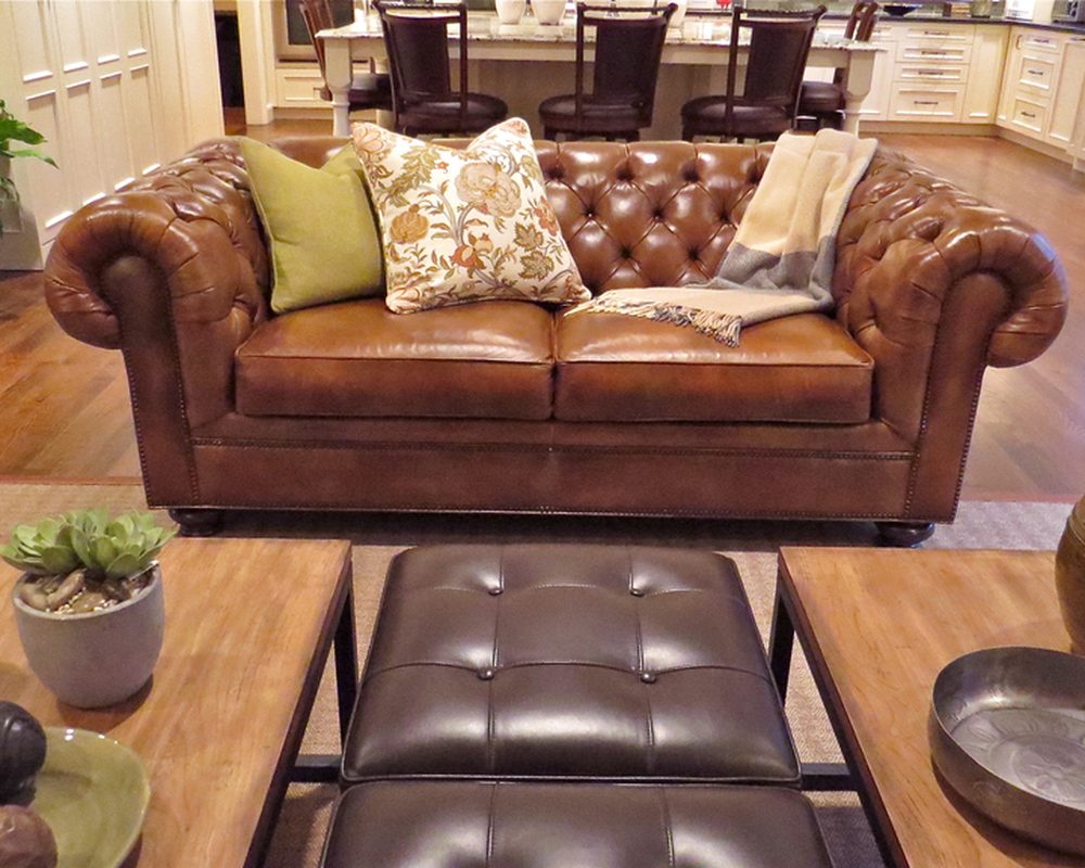 Leather chesterfield sofa with patterned cushions and potted succulents