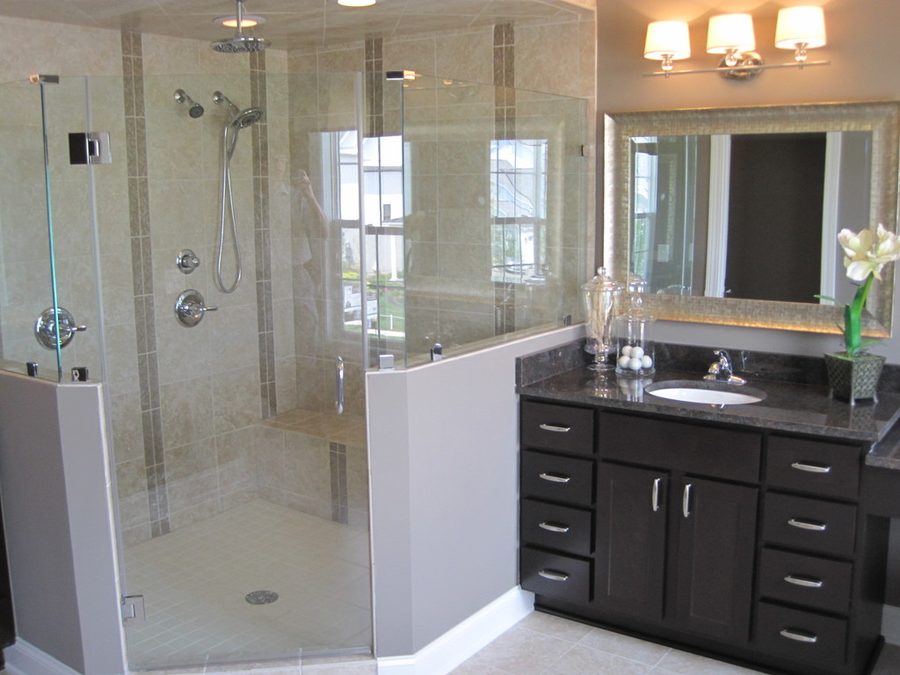 Modern bathroom with a frameless glass shower, stone tiles and a dark wood vanity