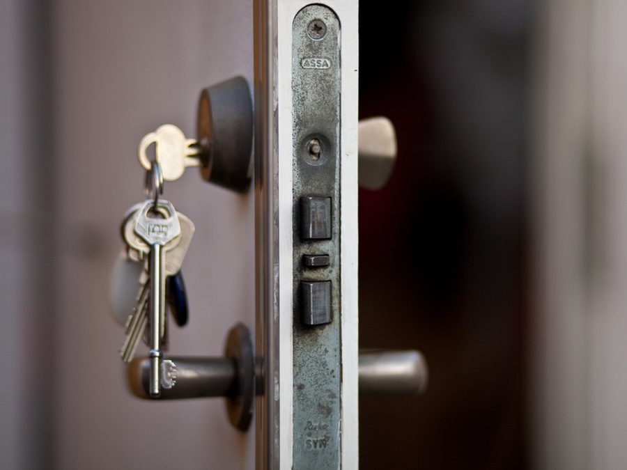 Bunch of house keys hanging from a front door lock
